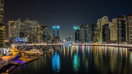 Obraz premium Dubai Marina towers and yachts in Dubai at night timelapse hyperlapse