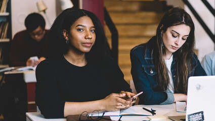 Focused young students working together in library