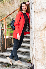 woman with brown hair and a red jacket is smiling