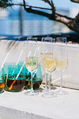 Elegant setup with champagne flutes and colorful drink glasses on an outdoor surface, perfect for a festive celebration or social gathering with a stylish touch