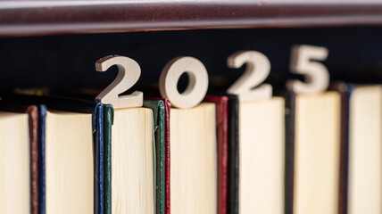 Número 2025 de madera sobre libros de una estantería de una biblioteca