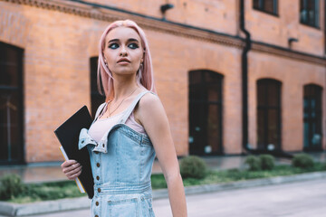 Young student walking on street and looking away