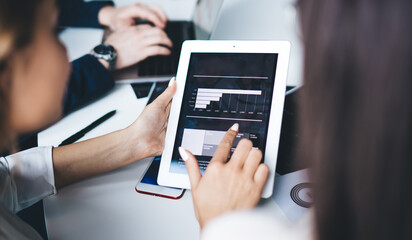 Modern woman working with chart at tablet at office