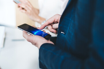 Side view of male office worker using smartphone