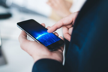 Back view of male office worker using smartphone