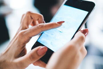 Crop hands using smartphone in office