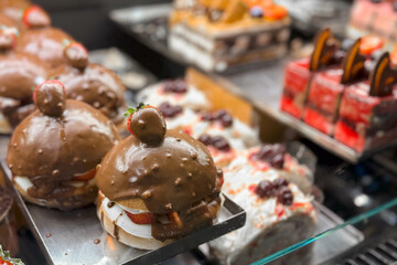 Close-up photo of a glass counter in a bakery or pastry shop with sweets, sponge cakes and chocolate cakes.