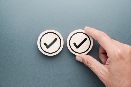 Hand adds another piece of wood with correct check mark in it, Double-Check concept