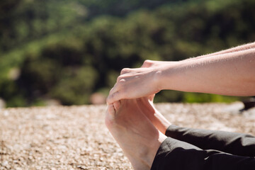 woman doing stretches, holding her legs with her hands, close-up