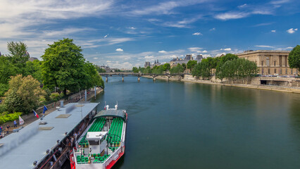 Naklejka premium Touristic boat passes below Pont des Arts and stop on boat station on Seine river timelapse hyperlapse in Paris.