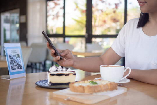 Woman use smartphone to scan QR code for order menu in cafe restaurant with a digital delivery. Choose menu and order accumulate discount. E wallet, technology, pay online, credit card, bank app..