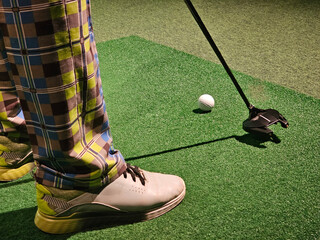 A man plays golf on a golf simulator and prepares to hit a shot. Practice putting in a golf...