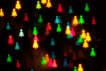 Christmas lights background. Blurred Christmas background, festive multicolor bokeh wallpaper. Holiday Christmas glowing color lights in form of the Christmas tree