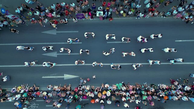 Aerial top down shot of crowds of people dancing in the streets. High angle drone footage of people street dancing salsa, bachata, west coast swing and tango seen from above. Open air music festival.

