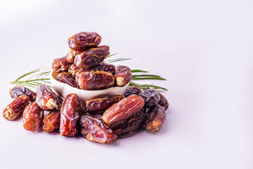 Dried date and green mint in a bowl on white table close up