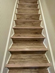 A flight of wooden stairs with wainscoting on the side walls of the stairwell.