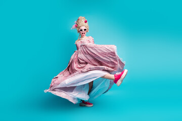 Full size portrait of young princess girl hold vintage dress dance footwear ad isolated on turquoise color background