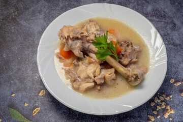 Boiled chicken thighs with potatoes and carrots in a white plate. Boiled chicken meat.