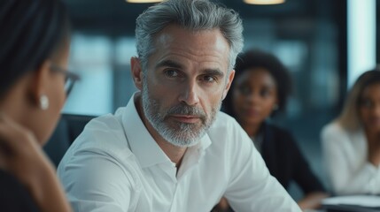Male mature caucasian ceo businessman leader with diverse coworkers team, executive managers group at meeting. Multicultural professional businesspeople working together on research plan in boardroom.