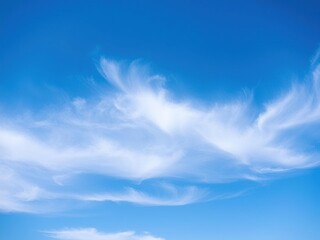 Obraz premium Thin and wispy white clouds stretch across the canvas of a brilliant blue sky, creating an ethereal atmosphere, delicate, clouds, dreamy scene
