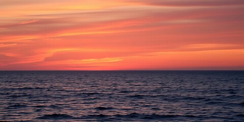 Obraz premium Warm hues of orange and pink bleed into the horizon as a serene sunset sky meets the vast expanse of ocean, gentle breeze, waves, water
