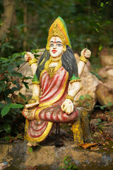 Devi maa forest indian goddess, sacred idol in jungle, nature-surrounded deity statue, van devi idol in forest, ancient temple in woods, rural deity sculpture, forest shrine stock photo.


