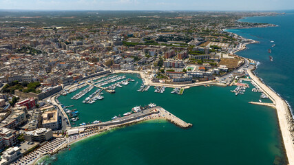 Fototapeta premium Aerial view of the historic center of Bisceglie, in Puglia, Italy. In the foreground is the tourist port, with many boats anchored, located on the Mediterranean Sea.