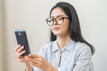 Presbyopia, Hyperopia middle aged asian woman holding eyeglasses problem with vision blurred ,trying to read text message from smart mobile phone screen, eye disease of old, eyesight farsightedness.