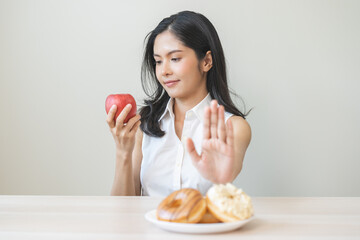 Diet asian young woman hand push out, refuse sugar donut, doughnut and sweet taste on plate and...