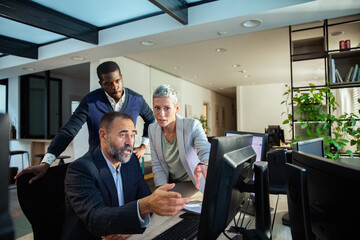 Diverse business people working together on office computer