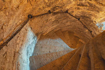 An ancient twisted stone staircase leading down.