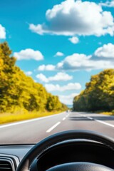 A scenic view from inside a car, showcasing a highway surrounded by lush greenery and vibrant clouds under a clear blue sky.