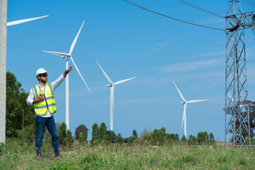 wind turbine and person. engineers point hand against turbines on wind turbine farm.