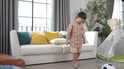 A special child with his mom playing soccer together in the living room of the house