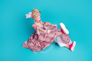 Photo of gorgeous cheerful lady princess wear pink medieval gown footwear sit floor isolated on blue color background