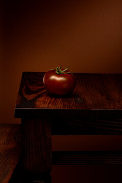 Fresh organic red tomato on dark wooden table