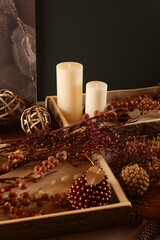 Cozy autumn decor with candles, pinecones, and berries, creating a rustic, seasonal ambiance perfect for fall.