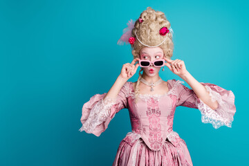 Photo of young woman touch sunglass look empty space wear renaissance queen costume isolated on teal color background