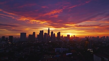 Obraz premium A stunning sunset over a city skyline, with vibrant red and orange clouds in the sky.