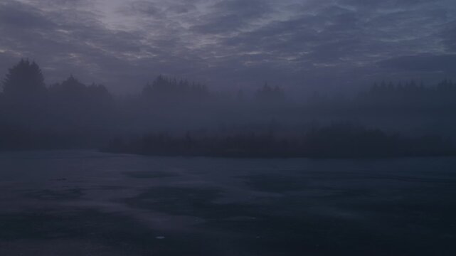Fog over desolate winter lake forest Reykjavik Iceland