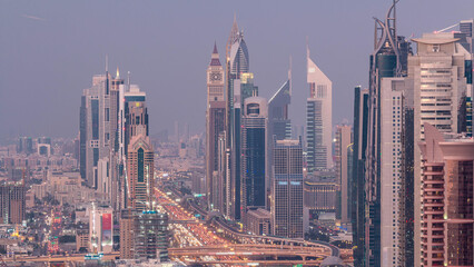 Obraz premium Aerial view to skyscrapers on Dubai downtown and Sheikh Zayed road day to night timelapse, Dubai, United Arab Emirates