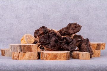 Empty wooden podium, pieces of snag of Mopani tree on grey background. Minimalist eco backdrop. Round natural wooden cross sections and snags. Copy space, front view.
