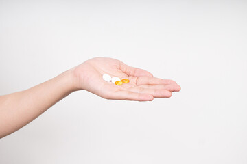 Woman hands taking multiple pills , vitamins D3 and Zinc, daily supplement vitamins isolated on white background