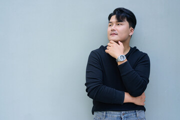 Portrait of Handsome Young Asian Man Against Plain Background Outdoors