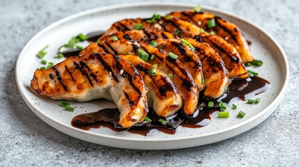 Grilled chicken dumplings with teriyaki glaze and chives on a plate