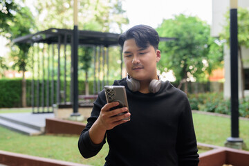 Portrait of Handsome Young Asian Man Outdoors in Park