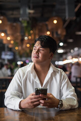 Portrait of Handsome Young Asian Man Sitting in Coffee Shop Restaurant
