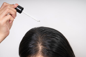 woman applying hair serum , hair care treatment and concept, strengthening and growth of hair