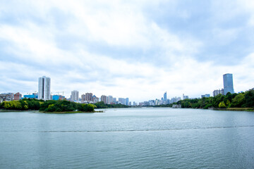a city with a river and trees and a bridge in the background.
