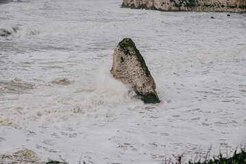 Waves hitting the rocks in the sea near the coastal island 